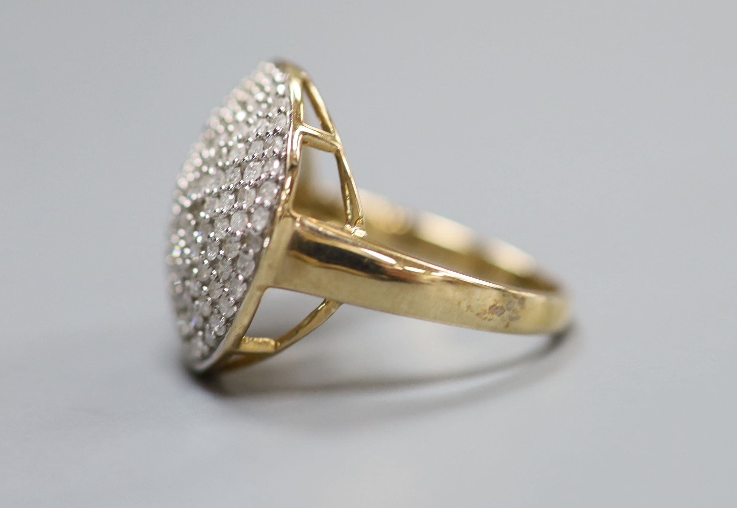 A modern 9kt and pave set diamond chip circular dress ring, size P, gross weight 4.8 grams.